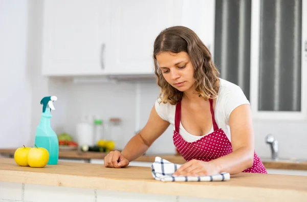 Focused Woman Wearing Apron Cleaning Countertop Kitchen Rag Detergent — Zdjęcie stockowe
