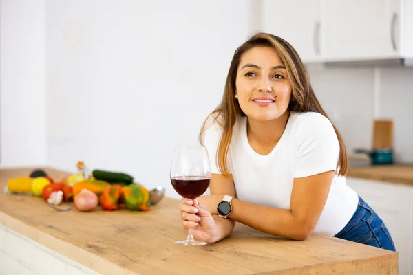 Cheerful Young Latin American Housewife Drinking Wine While Standing Table — Stock Photo, Image