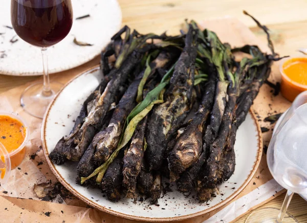 stock image Calcot onion prepared according to catalan traditions served with romesco sauce