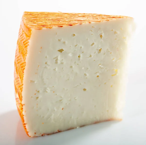 Appetitliche Scheibe Halbweicher Käse Auf Einer Weißen Oberfläche Hochwertiges Foto — Stockfoto