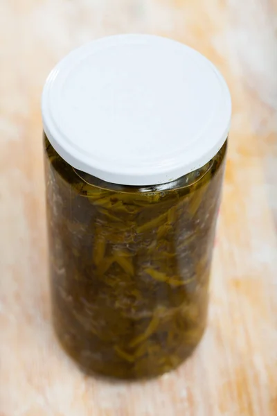 木制表面玻璃瓶中的罐头绿色菠菜 — 图库照片