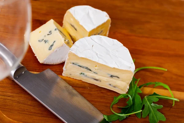 木制切菜板上的软蓝色奶酪片 — 图库照片