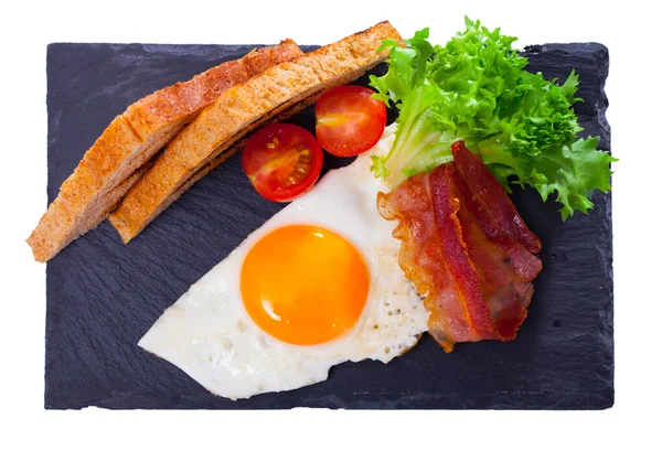 Πεντανόστιμο Πρωινό Τηγανητά Αυγά Μπέικον Ψωμί Και Λαχανικά Γαρνιτούρα Μαύρο — Φωτογραφία Αρχείου