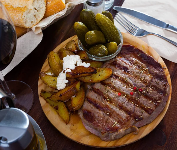 Appetizing Beef Strip Steak Served Gherkins Potato Wedges Wooden Platter — Stock Photo, Image