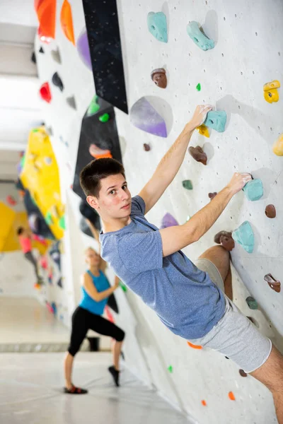 Europese Jonge Man Grijpen Richels Van Kunstmatige Klimwand Bouldering Centrum — Stockfoto