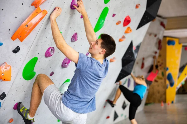 在墙上攀爬体育馆锻炼的白人年轻人 — 图库照片