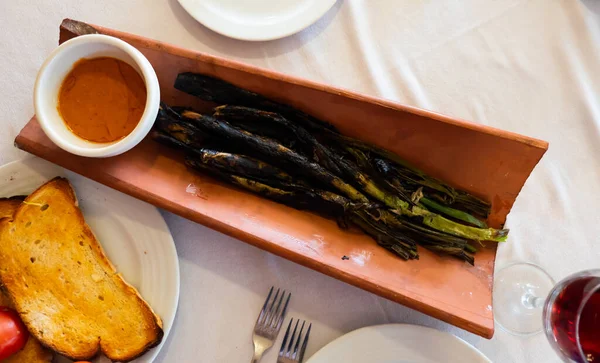 stock image Popular delicious dish of Catalan cuisine called Calso, made from white onions grown by a special method, with ..Romesco sauce