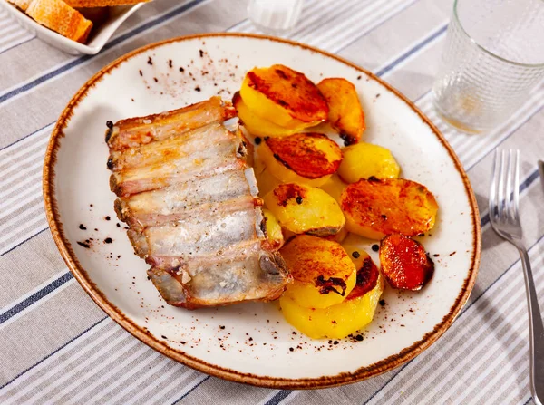 揚げ黄金焼きジャガイモとプレート上で提供されるロースト肉豚リブ — ストック写真