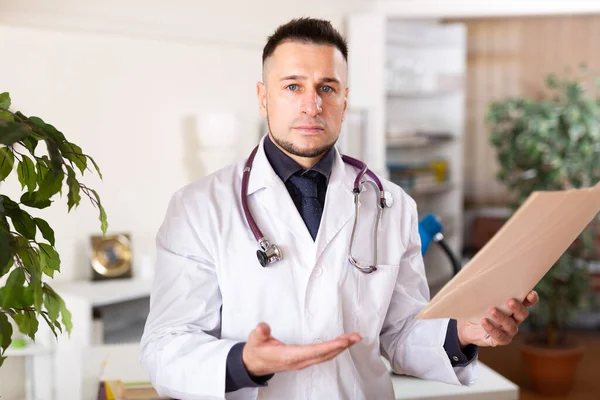 Médico Masculino Vestido Branco Seu Escritório Com Papéis Nas Mãos — Fotografia de Stock