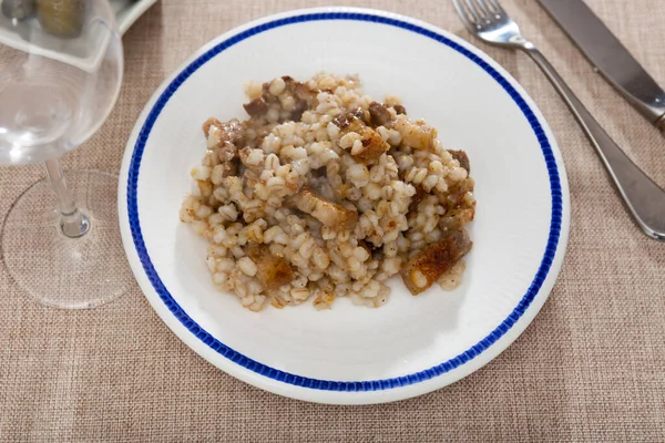 for lunch,restaurant serves traditional Russian dish - stewed barley porridge with fried lard and wine of your choice