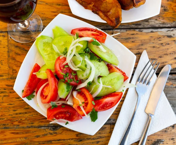 新鮮なトマトから作られたプレート内のおいしい夏の野菜サラダのイメージ キュウリ タマネギのリングと振りかけ パセリ — ストック写真