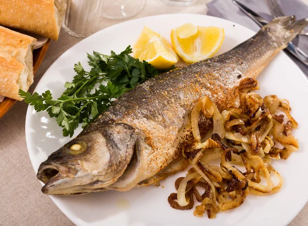 味道鲜美的鱼 烤好的海鲈鱼 配洋葱 柠檬和欧芹 — 图库照片