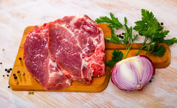 stock image Sliced raw pork chop with parsley and onion. High quality photo