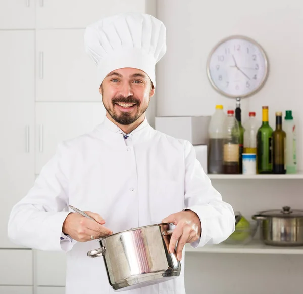 Young Male Cook Tasting Food While Preparing Kitchen — Stock Photo, Image