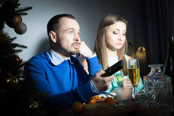新年を祝う不幸なカップル家でテレビを見て — ストック写真
