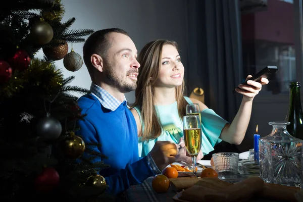 家庭で新年を祝う幸せなカップル 一緒にお祝いのテレビ番組を見ます — ストック写真