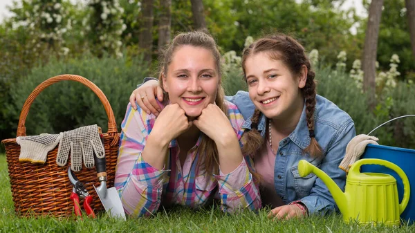 年轻的高加索妇女和女孩带着园艺工具在户外微笑 — 图库照片