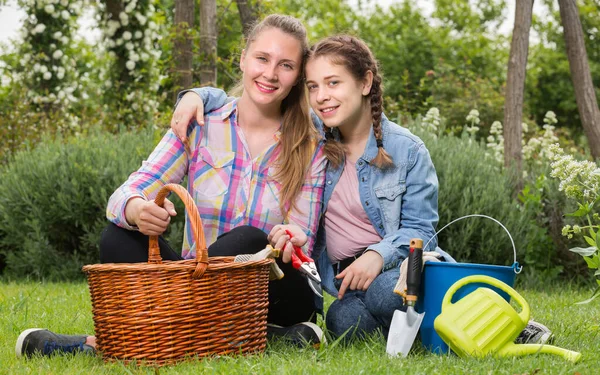 積極的な若い母親と屋外の園芸ツールを持つ娘 — ストック写真