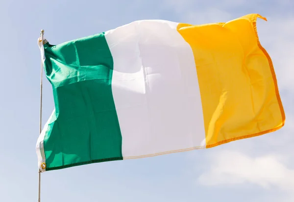 アイルランドの緑 オレンジの旗 アイルランドの文化と歴史の象徴 青い空を背景に旗スタッフに手を振ってゲール語とプロテスタントの伝統の団結の希望を表す — ストック写真