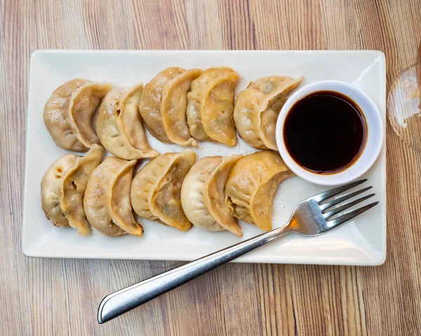盘子里是中国饺子和小碗酱油叉子的一部分 选择性重点 — 图库照片