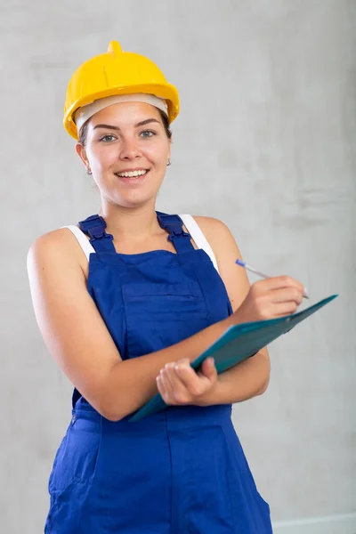 Cheerful Female Worker Overalls Hardhat Writing File — Stock Photo, Image