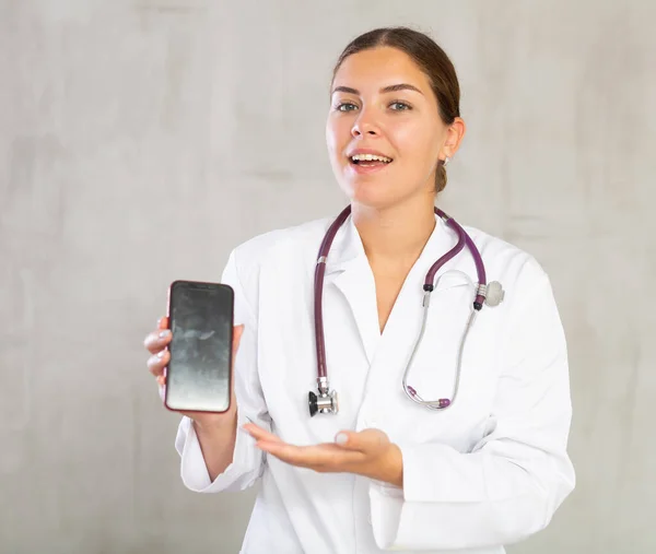 Жінка Лікар Білому Пальто Розтягує Руку Телефоном Показує Екран Вибірковий — стокове фото