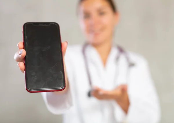 Female Doctor White Coat Extending Hand Phone Showing Screen Selective — Stock Photo, Image