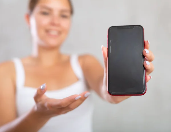 stock image Smiling woman in casual clothes showing the screen of her phone