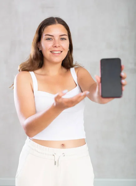Glimlachende Vrouw Casual Kleding Toont Het Scherm Van Haar Telefoon — Stockfoto