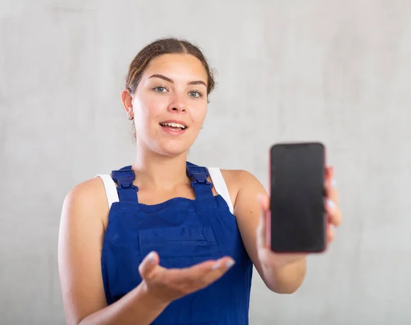 Trabalhador Feminino Alegre Macacão Mostrando Tela Seu Telefone — Fotografia de Stock