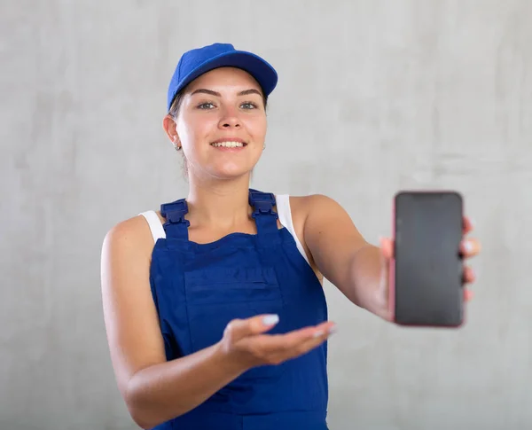 Jovem Trabalhadora Macacão Posando Estúdio Com Telefone Celular Suas Mãos — Fotografia de Stock