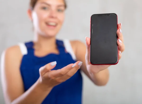 Tulumlu Neşeli Bayan Işçi Telefonunun Ekranını Gösteriyor — Stok fotoğraf