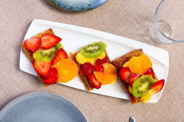 脆而片状的黄油油酥糕点与精美的香草奶油馅 顶部有彩色水果和浆果片 受欢迎的西班牙甜点 — 图库照片