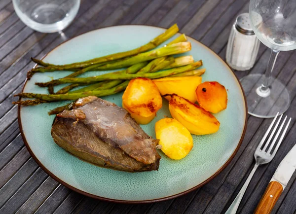 stock image Portion of just cooked beef tenderloin with potatoes and asparagus. Grilled food on table.