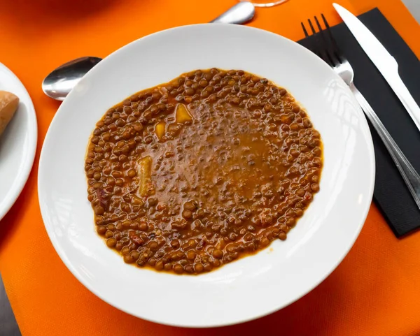 Just cooked Spanish lentil soup, sopa de lentejas, served on plate.