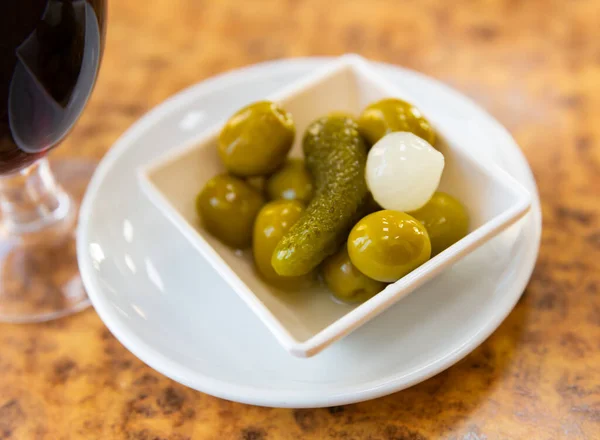 おいしい漬物のオリーブとプレート ダイニングテーブル上のガーキンとベビー玉ねぎ スペインの人気スナック — ストック写真