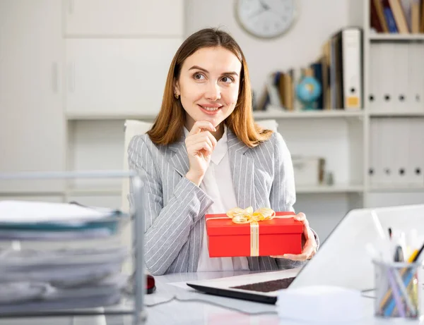 Nachdenkliche Frau Mit Roter Geschenkbox Sitzt Büro Tisch — Stockfoto