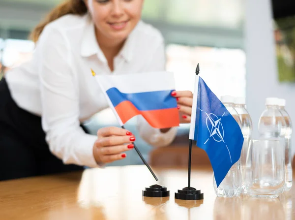 Νεαρή Γυναίκα Βοηθός Στήνει Σημαίες Νατο Και Ρωσίας Για Τις — Φωτογραφία Αρχείου