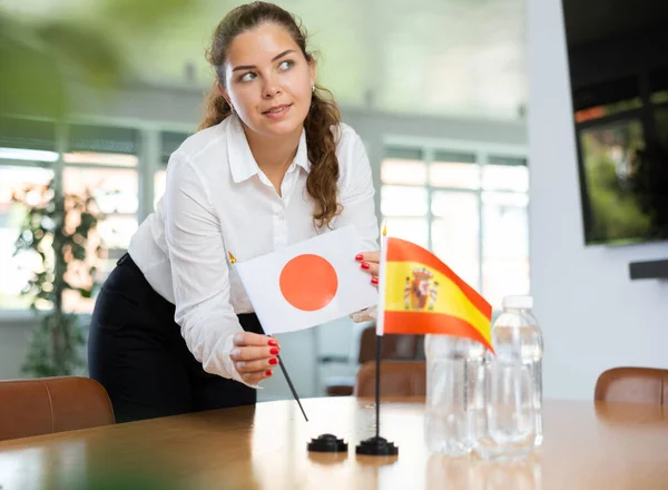Jonge Vrouw Zakelijke Kleding Zet Vlaggen Van Japan Spanje Onderhandelingstafel — Stockfoto