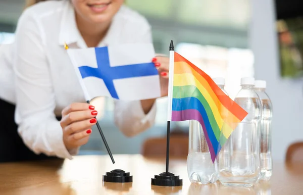 Jonge Vrouw Bedrijfskleding Zet Vlaggen Van Finland Lgbt Onderhandelingstafel — Stockfoto