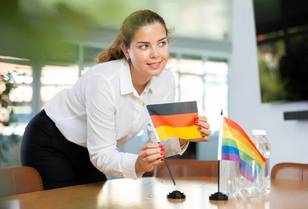 Nierozpoznawalna Dziewczyna Ustawia Miniaturowe Flagi Lgbt Niemieckie Przed Międzynarodowymi Rozmowami — Zdjęcie stockowe