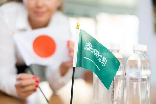 Маленький Флаг Саудовской Аравии Столе Бутылками Воды Флагом Японии Поставили — стоковое фото