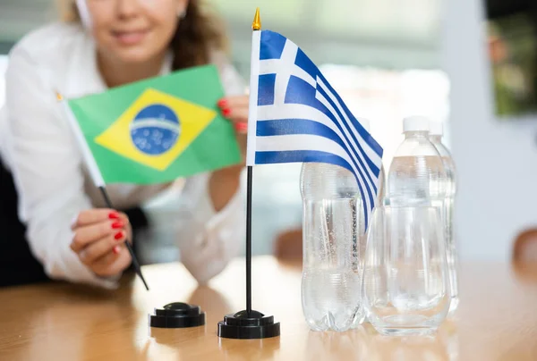 Jovem Assistente Montando Bandeiras Gregas Brasileiras Para Negociações Internacionais — Fotografia de Stock