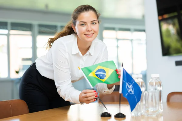 Ung Kvinnlig Assistent Inrätta Nato Och Brasilianska Flaggor För Internationella — Stockfoto