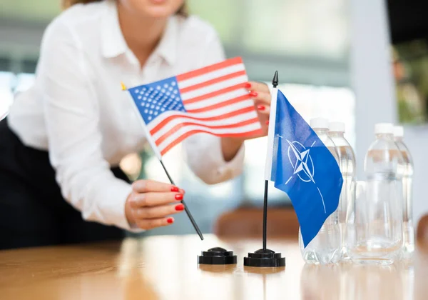Jonge Vrouwelijke Assistent Opzetten Nato Amerikaanse Vlaggen Voor Internationale Onderhandelingen — Stockfoto