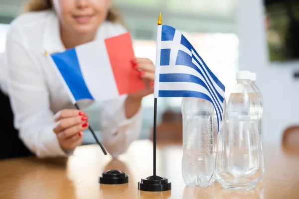 Genç Bayan Asistan Uluslararası Müzakereler Için Yunanca Fransızca Bayraklar Kuruyor — Stok fotoğraf