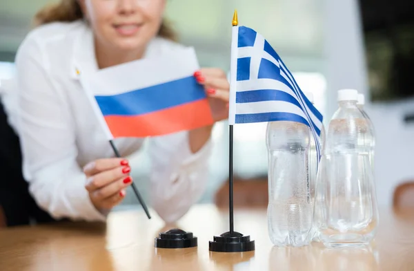 Молодая Ассистентка Устанавливает Греческие Российские Флаги Международных Переговоров — стоковое фото