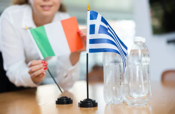 Молодая Ассистентка Устанавливает Греческие Итальянские Флаги Международных Переговоров — стоковое фото
