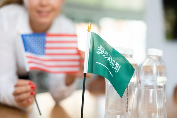 商务会议的准备工作 秘书把沙特阿拉伯和美国的国旗放在谈判桌上 — 图库照片