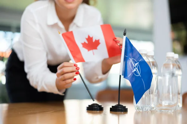 Genç Bayan Asistan Uluslararası Görüşmeler Için Nato Kanada Bayrakları Kuruyor — Stok fotoğraf